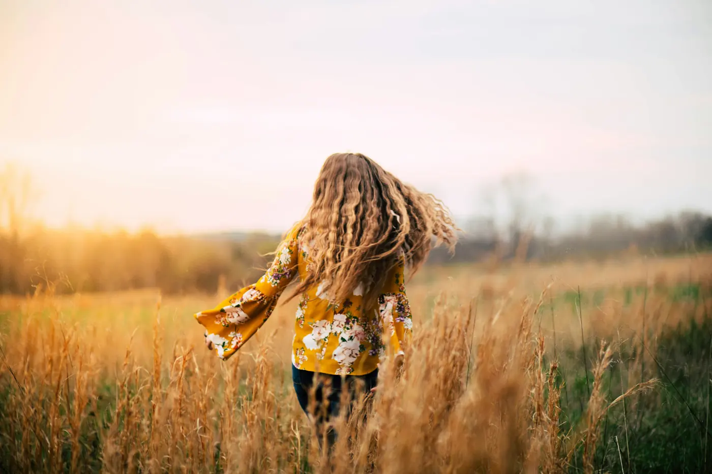 Walking through the meadow grasses at golden hour at Kilvington Lakes