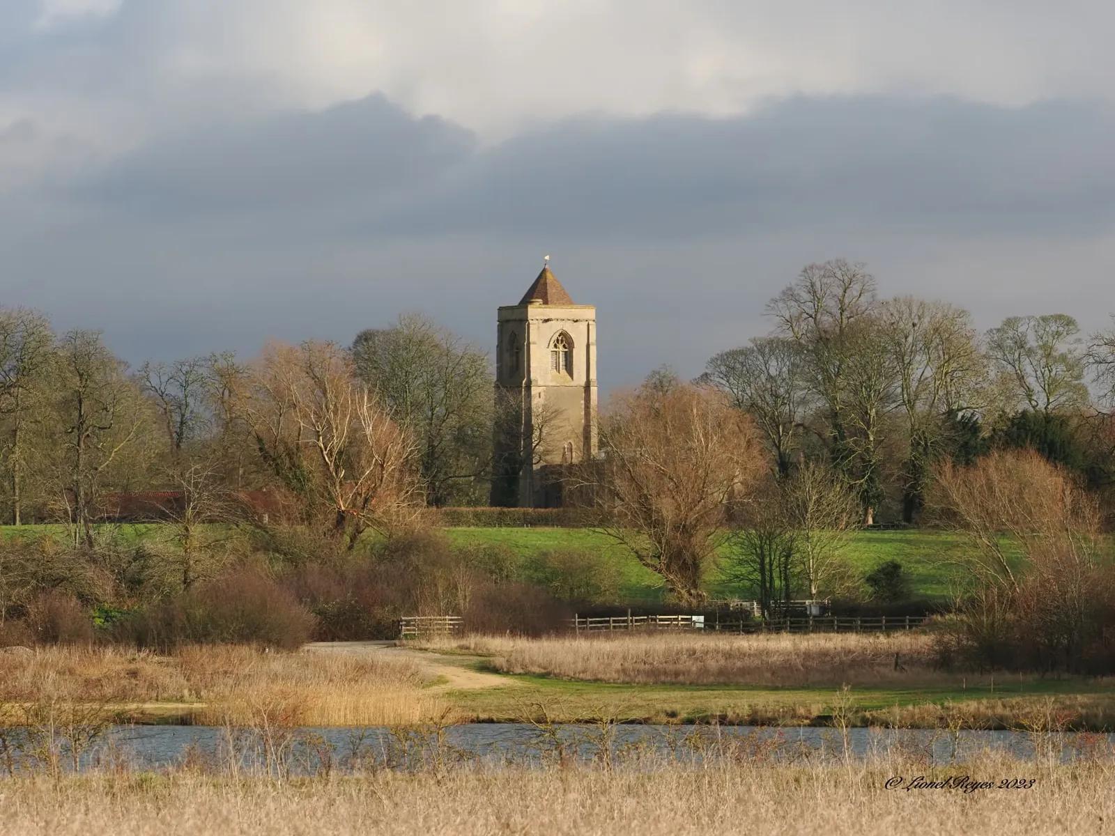 The village church tower across the meadows